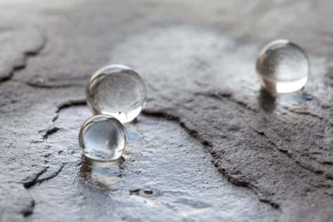 Water pearls on wet stone surface.